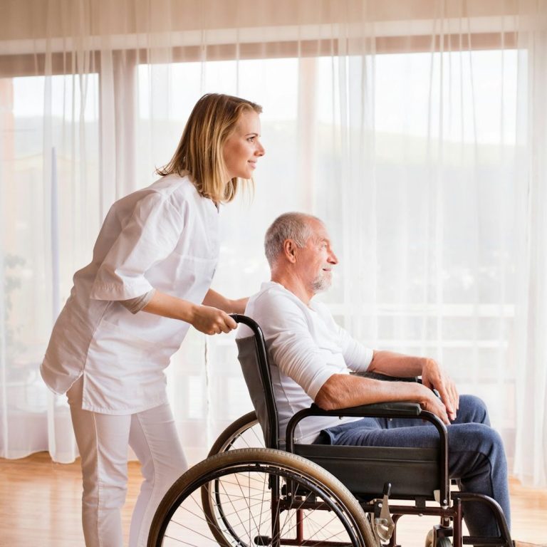 Mujer mayor sonriente leyendo un libro en un ambiente acogedor.